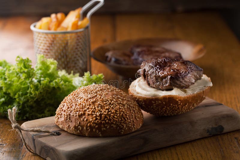 Heerlijke hamburger met vlees, kaas, sla en frieten stock afbeeldingen Heerlijke hamburger met vlees, kaas, sla en frieten stock afbeeldingen