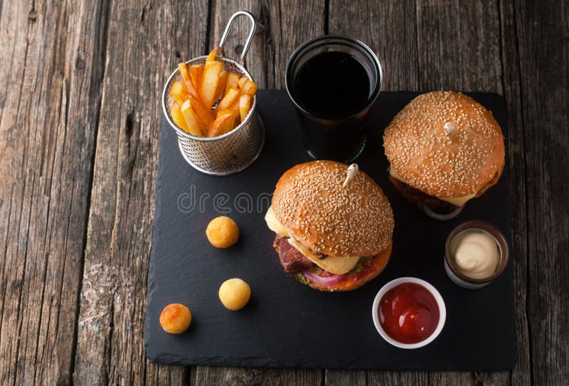 Heerlijke hamburger met vlees, kaas, sla en frieten stock fotografie Heerlijke hamburger met vlees, kaas, sla en frieten stock fotografie