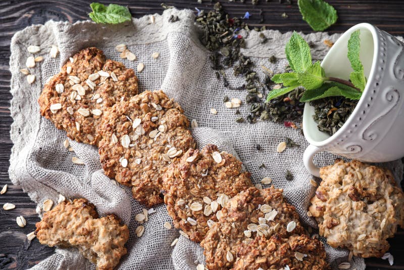 Heerlijke havermeelkoekjes met droge groene thee op lijst stock fotografie Heerlijke havermeelkoekjes met droge groene thee op lijst stock fotografie