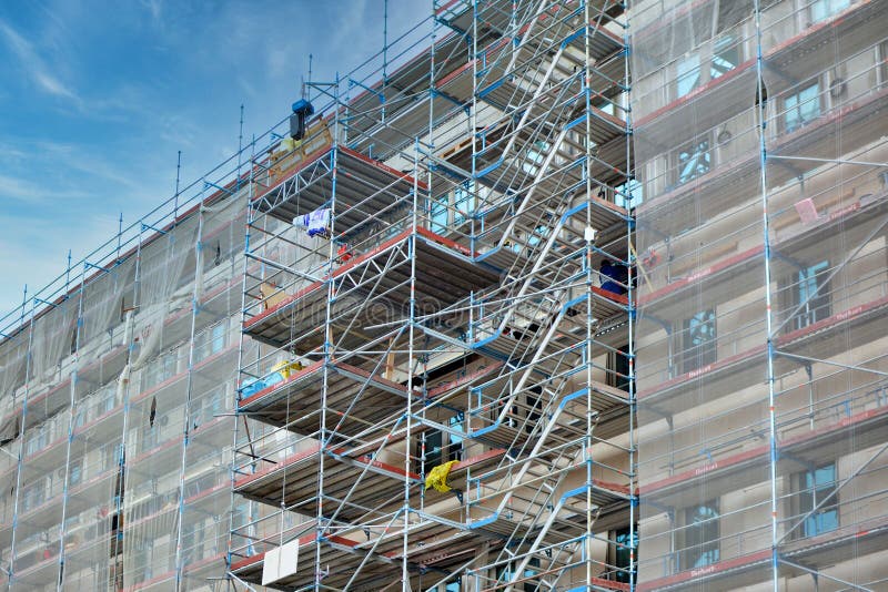 Part of construction site with scaffolding on multistory building facade during renovation in city center