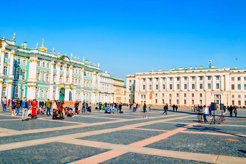 Heilige Petersburg, Rusland De Kluismuseum van de staat of de Winterpaleis en toeristen die bij het Paleisvierkant lopen royalty-vrije stock fotografie Heilige Petersburg, Rusland De Kluismuseum van de staat of de Winterpaleis en toeristen die bij het Paleisvierkant lopen royalty-vrije stock fotografie