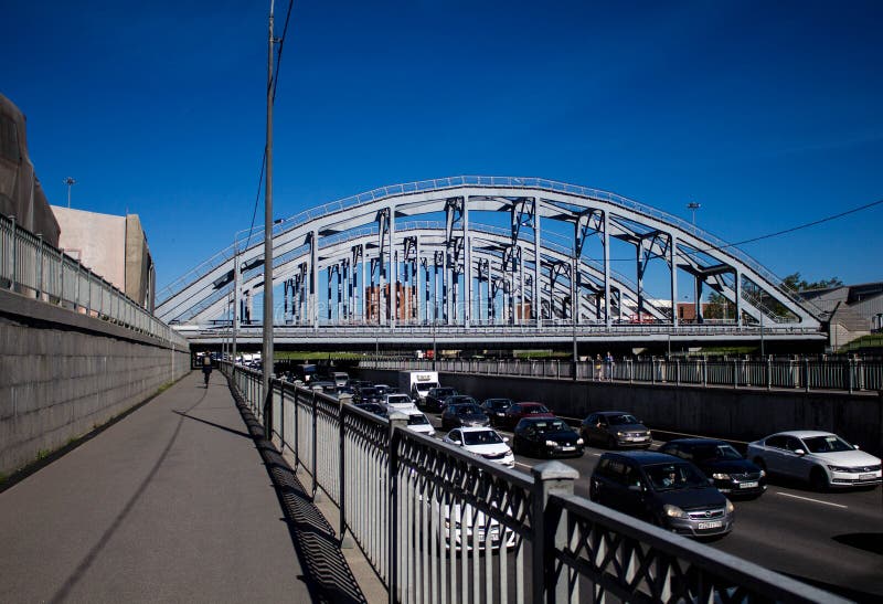 Heilige Petersburg, Rusland, kan 2019, de dijk van het omleidingskanaal en de spoorwegbrug Verkeer op een Zonnige dag royalty-vrije stock fotografie Heilige Petersburg, Rusland, kan 2019, de dijk van het omleidingskanaal en de spoorwegbrug Verkeer op een Zonnige dag royalty-vrije stock fotografie
