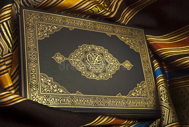 The revered cover of the Holy Quran lies gracefully atop an intricately designed Arabic art-patterned cloth. The combination highlights the profound depth and richness of Islamic heritage and teachings. The revered cover of the Holy Quran lies gracefully atop an intricately designed Arabic art-patterned cloth. The combination highlights the profound depth and richness of Islamic heritage and teachings.