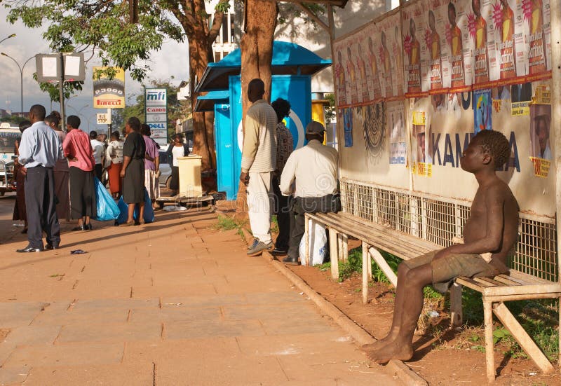 Obdachloser Junge sitzt auf einer Bank lizenzfreie stockfotos