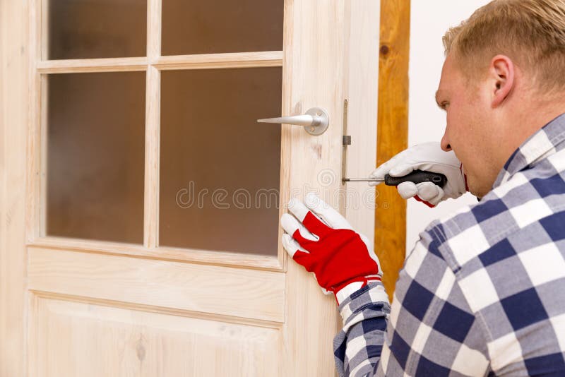 Heimwerker, der die Tür mit Schraubenzieher repariert