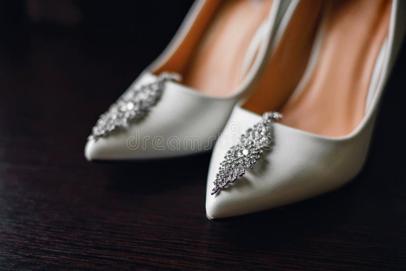 Heiratende weiße Brautschuhe mit silbernen Ohrringen stockbild Heiratende weiße Brautschuhe mit silbernen Ohrringen stockbild