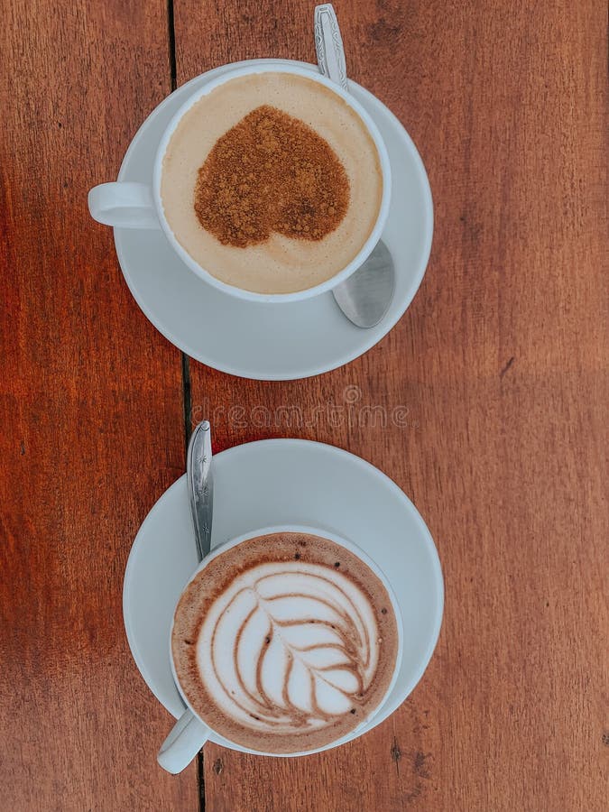 2 cups of coffee and hot chocolate with a beautiful touch of latte art. 2 cups of coffee and hot chocolate with a beautiful touch of latte art