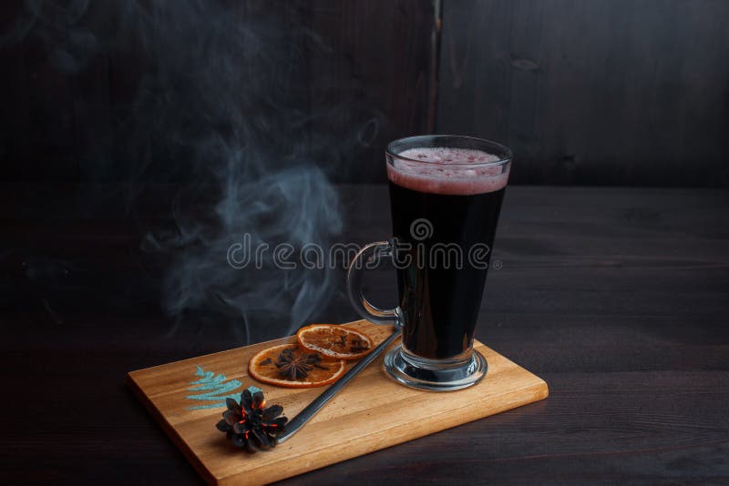 Heißes köstliches würziges verrührte den Rotwein, der mit getrockneten orange Scheiben geschmückt wurden und einen schwelenden St lizenzfreie stockfotografie Heißes köstliches würziges verrührte den Rotwein, der mit getrockneten orange Scheiben geschmückt wurden und einen schwelenden St lizenzfreie stockfotografie