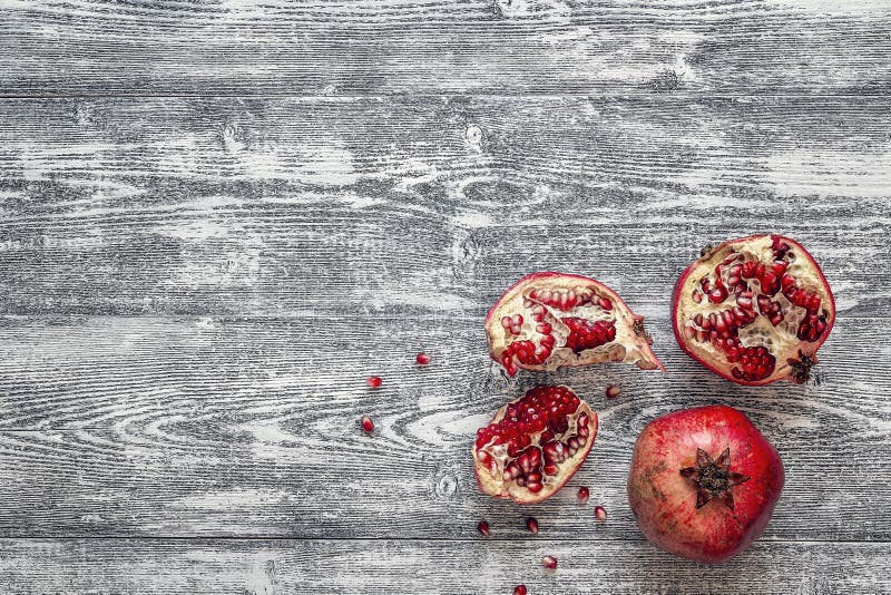Hel ny saftig granatäpple - och snitt på en trägrå backgro arkivfoton Hel ny saftig granatäpple - och snitt på en trägrå backgro arkivfoton