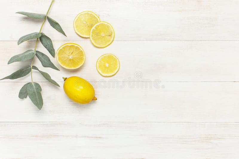 Hel och skivad ny citron, eukalyptussidor på vit träbakgrund Lekmanna- lägenhet, bästa sikt, kopieringsutrymme Minsta fruktbegrep royaltyfria foton Hel och skivad ny citron, eukalyptussidor på vit träbakgrund Lekmanna- lägenhet, bästa sikt, kopieringsutrymme Minsta fruktbegrep royaltyfria foton