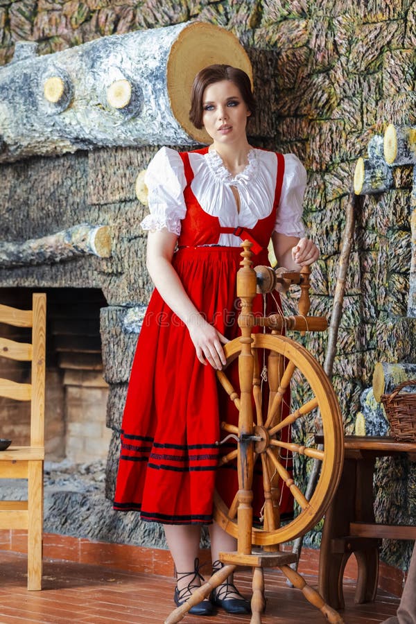 Hela porträttet av unga caucasiska brunette som possar med roterande hjul i återklänningen i bymiljön royaltyfri fotografi