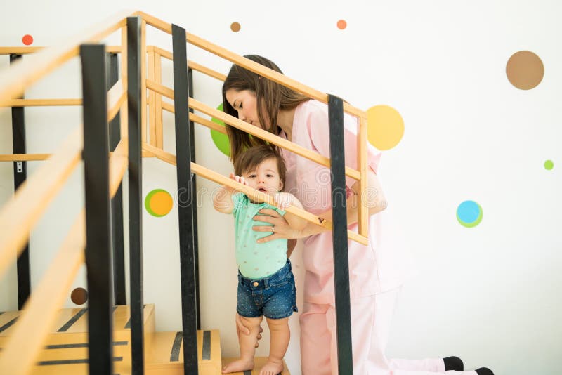 Helfendes Baby des Therapeuten Treppe klettern lizenzfreie stockfotos Helfendes Baby des Therapeuten Treppe klettern lizenzfreie stockfotos