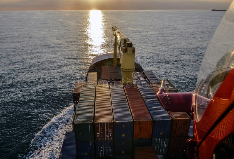 Helicopter Flying Over A Container Ship Seen From The Sky Crossing The