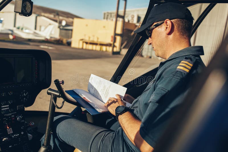 Helicopter pilot reading a manual book