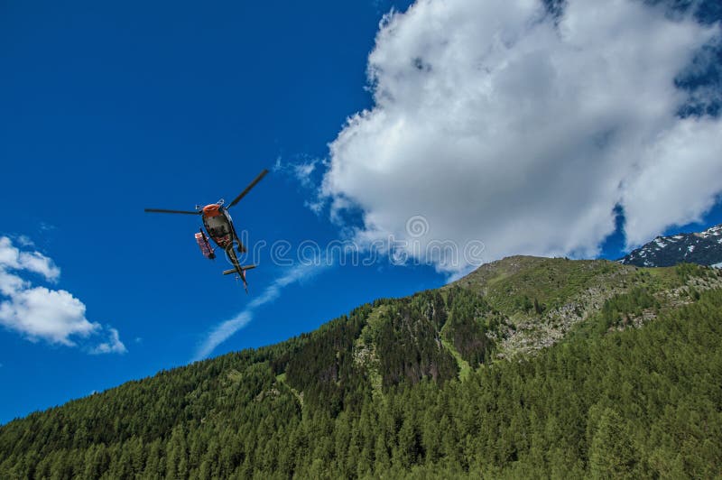 Helicopter taking off in a forest at ArgentiÃ¨re.