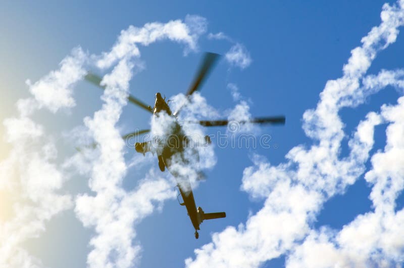 Helicóptero militar detrás del humo de los misiles foto de archivo libre de regalías Helicóptero militar detrás del humo de los misiles foto de archivo libre de regalías