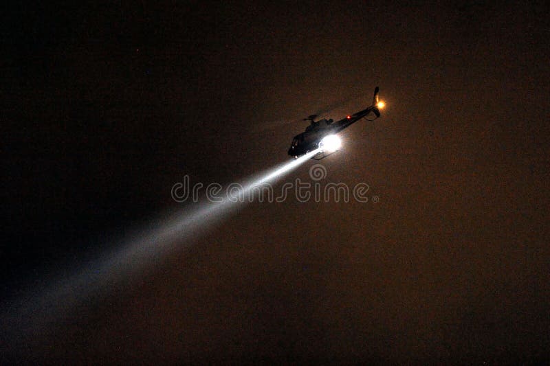 Helikopter Policyjny z reflektorem przy nocą