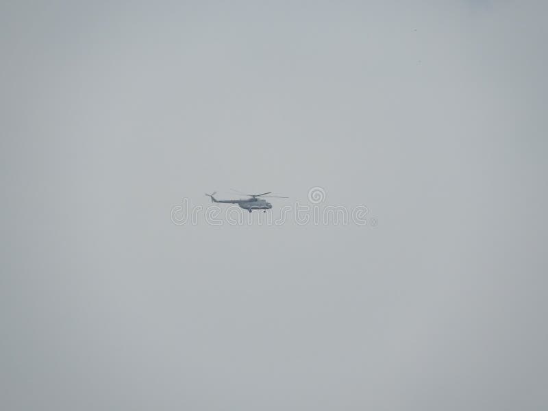 Helikoptern flyger i en dyster molnig himmel, Moskvaregion royaltyfri fotografi Helikoptern flyger i en dyster molnig himmel, Moskvaregion royaltyfri fotografi