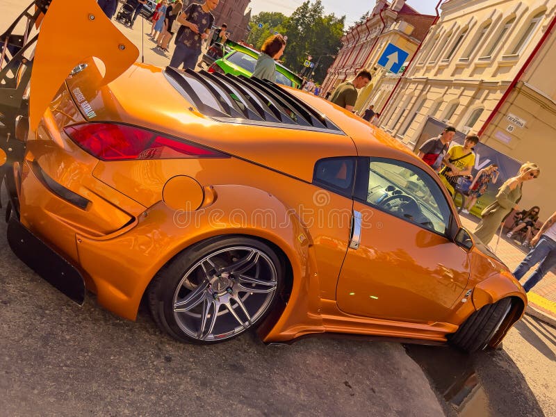 Russia Tomsk, June 2022 modern sports car on street. Using wallpaper for transport or automobile car technology. Bright, golden brown Nissan in restyling or body kit for racing on urban asphalt roads. Russia Tomsk, June 2022 modern sports car on street. Using wallpaper for transport or automobile car technology. Bright, golden brown Nissan in restyling or body kit for racing on urban asphalt roads.