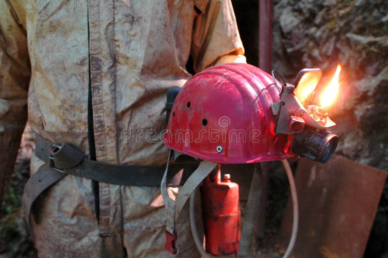 L'uomo delle caverne tenere il casco con il fuoco di luce.