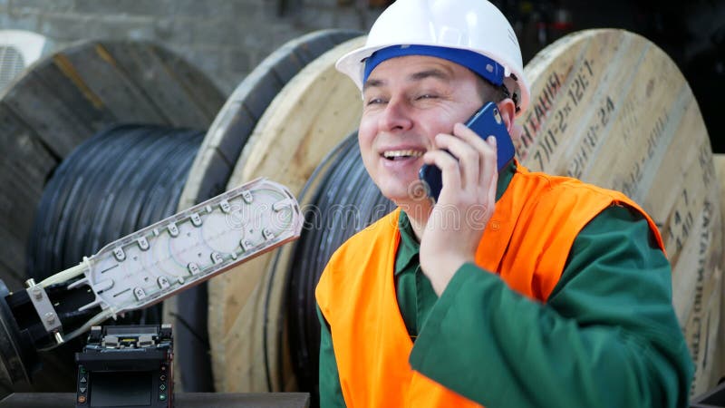 Helmet engineer talking on a cell phone. Worker talking on a smartphone in the workplace