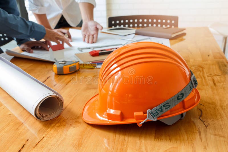Helmet on wooden desk with architect royalty free stock image Helmet on wooden desk with architect royalty free stock image