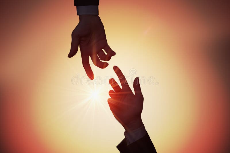 Help and assistance concept. Two hands are reaching each other at sunset.