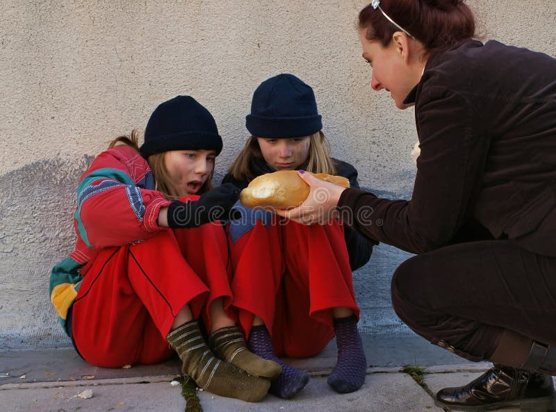 Due tristi giovani ragazze (sorelle-gemelle) seduto sul marciapiede (piano), a piedi nudi, affamati, sporchi e freddi.