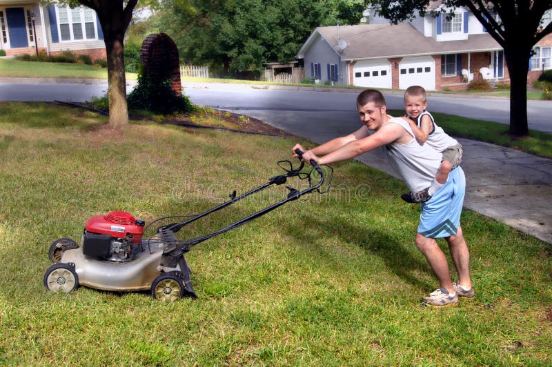 Little boy rides piggy back while dad mows the family's front yard. 