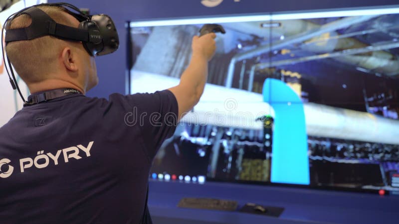HELSINKI, FINLAND - MAY 30, 2018: Engineer are using virtual AR to simulate industrial space, repair and design various technological designs. Industry 4. 0 concept by finnish company Poyry during the exhibition PacTec in Helsinki