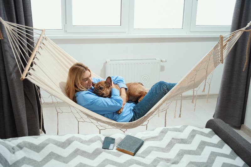 Hembra abrazando a su perrito favorito durante el descanso de la tarde foto de archivo libre de regalías