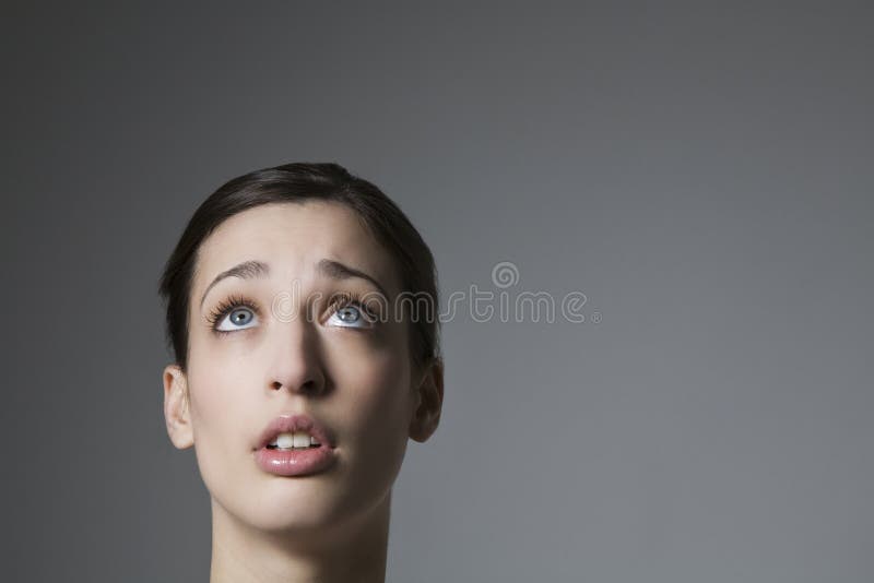 Hembra joven asustada que mira hacia arriba imagen de archivo Hembra joven asustada que mira hacia arriba imagen de archivo