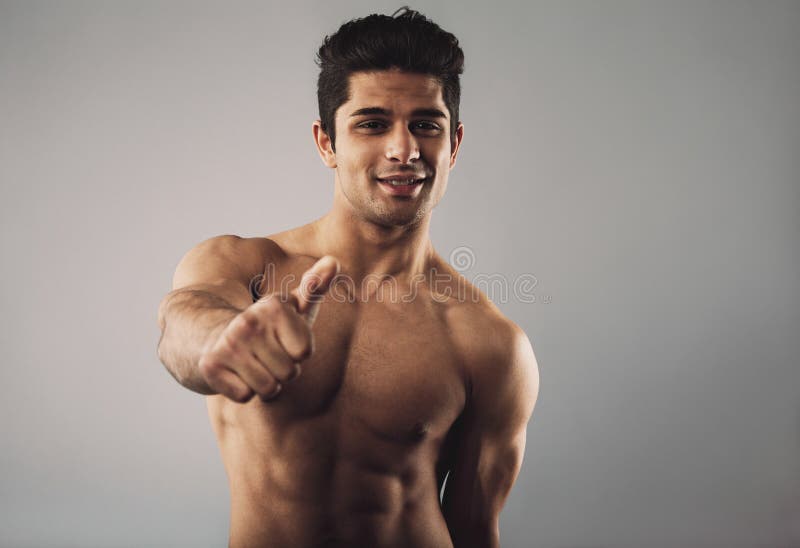 Hemdloser junger hispanischer Mann, der Ihnen gutes Glück wünscht lizenzfreies stockbild Hemdloser junger hispanischer Mann, der Ihnen gutes Glück wünscht lizenzfreies stockbild