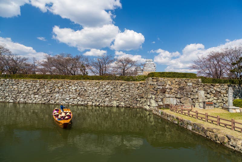 Hemeji slott i vår med den körsbärsröda blomningen och det turist- fartyget, Japan arkivbild Hemeji slott i vår med den körsbärsröda blomningen och det turist- fartyget, Japan arkivbild