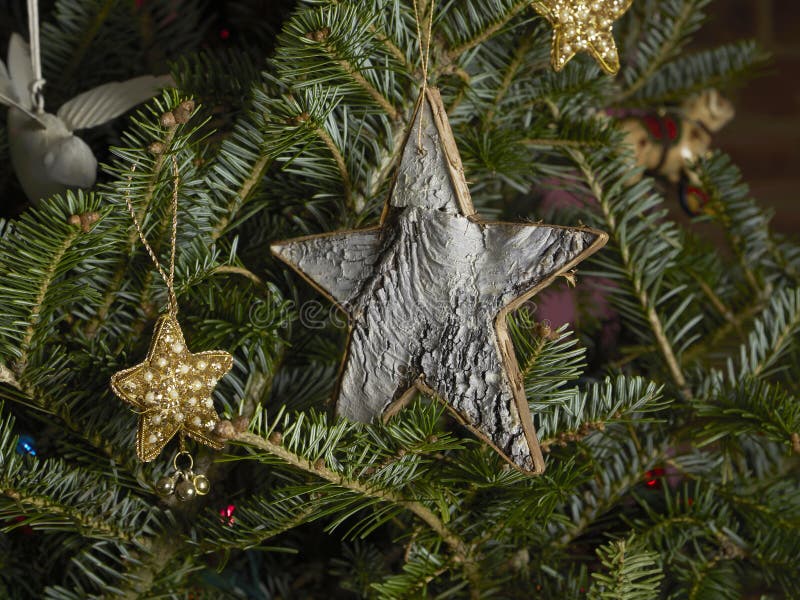 Home made birch bark Christmas ornament with beaded star ornaments in an evergreen tree. Home made birch bark Christmas ornament with beaded star ornaments in an evergreen tree