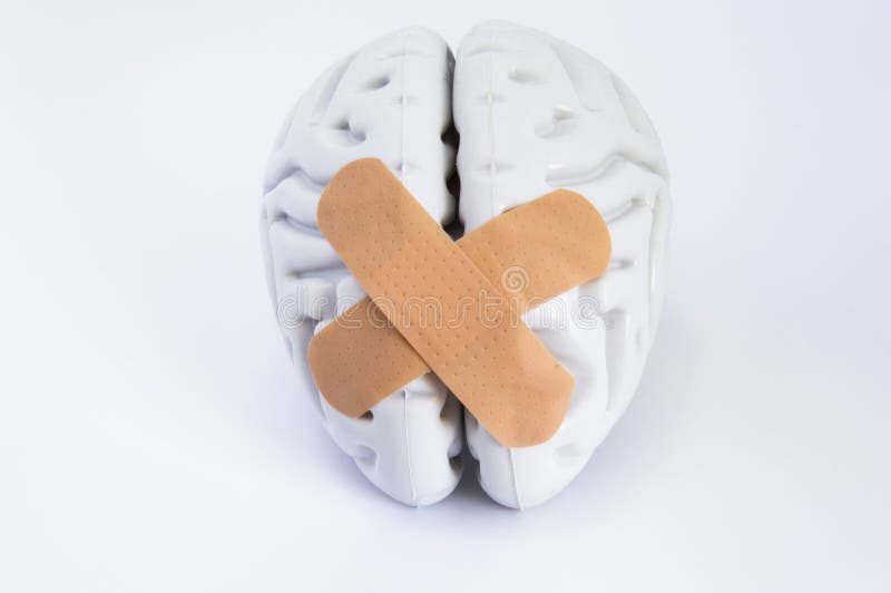 Hemispheres of human brain, stuck together using beige adhesive tape treatment, lying on white background. Idea for visualizing brain treatment of neurological diseases such as broken brain syndrome