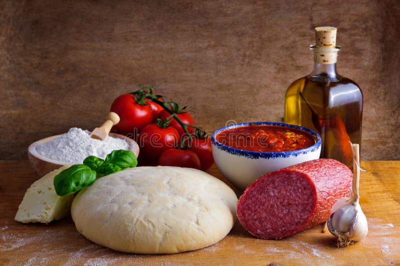 Still life with traditional homemade salami pizza ingredients and dough. Still life with traditional homemade salami pizza ingredients and dough