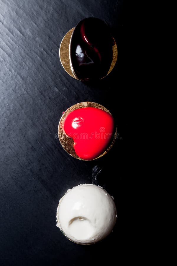 Hemlagad ljus mousse bakar ihop med spegelglasyr på en svart backgr arkivfoto Hemlagad ljus mousse bakar ihop med spegelglasyr på en svart backgr arkivfoto