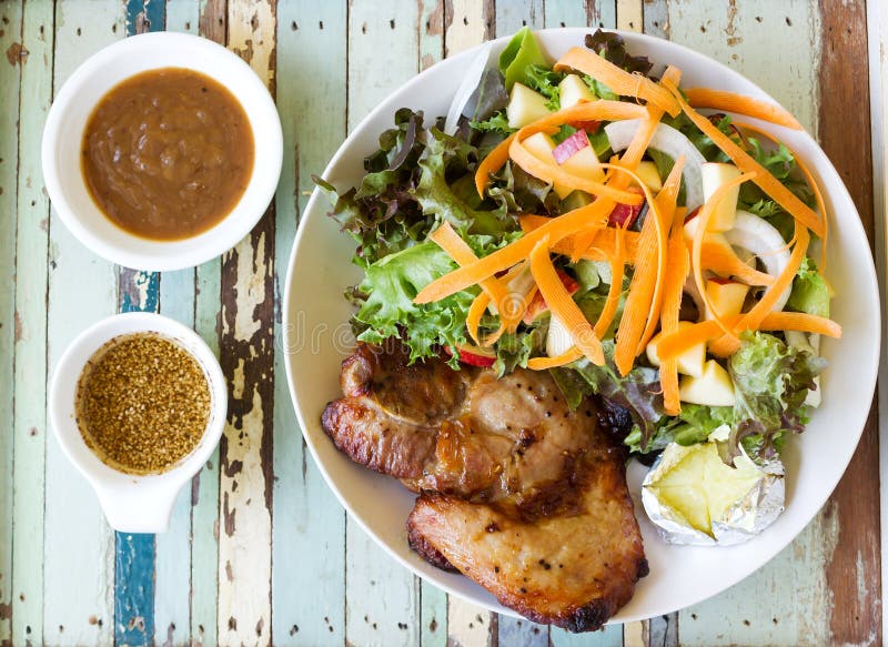 Hemlagad svartpepparfläskkotlettbiff med sallad arkivfoton Hemlagad svartpepparfläskkotlettbiff med sallad arkivfoton