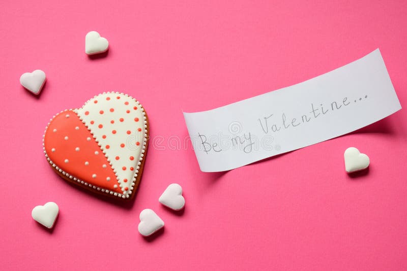 Hemlagade pepparkakahjärtor och papper med text att vara min valentin Kakahjärtor på rosa bakgrund Ätlig nolla för valentindaggåv royaltyfri foto Hemlagade pepparkakahjärtor och papper med text att vara min valentin Kakahjärtor på rosa bakgrund Ätlig nolla för valentindaggåv royaltyfri foto