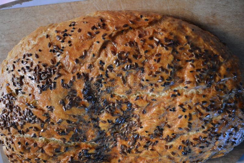 Hemlagat recept för härligt mycket hurtigt bröd Brunt bröd med den frasiga skorpan, frö för svart kummin och bruna linkärnor royaltyfri fotografi Hemlagat recept för härligt mycket hurtigt bröd Brunt bröd med den frasiga skorpan, frö för svart kummin och bruna linkärnor royaltyfri fotografi