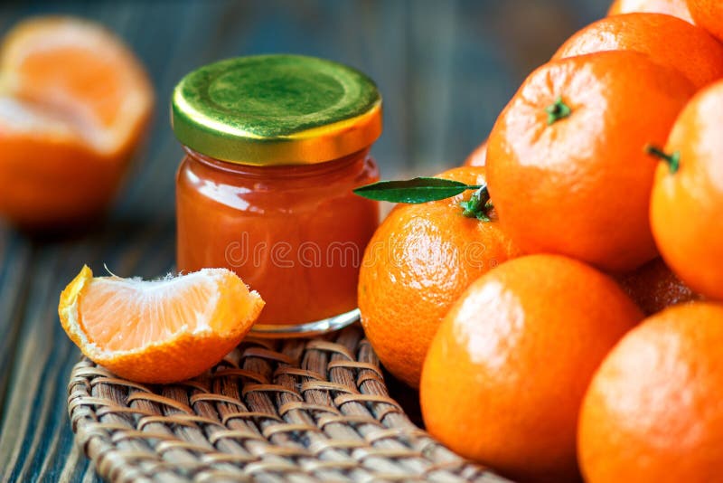 Hemlagat tangerindriftstopp i den glass kruset med frukt omkring på en trätabell fotografering för bildbyråer Hemlagat tangerindriftstopp i den glass kruset med frukt omkring på en trätabell fotografering för bildbyråer