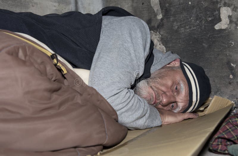 Homeless man sleeping on cardboard and an old sleeping bag out on the streets. Homeless man sleeping on cardboard and an old sleeping bag out on the streets