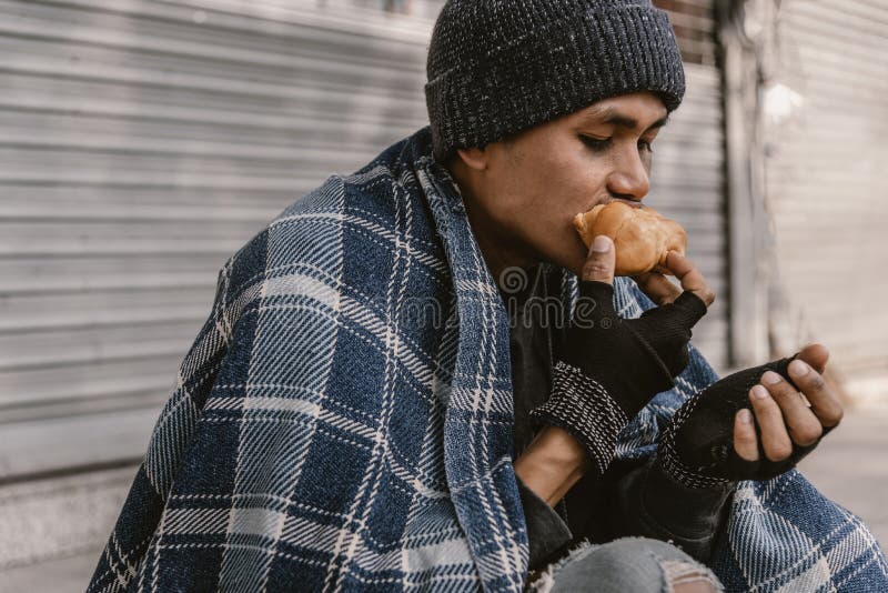 Homeless man eating sandwich on the street. Homeless man eating sandwich on the street.