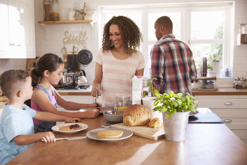 Family At Home Eating Breakfast In Kitchen Together. Family At Home Eating Breakfast In Kitchen Together