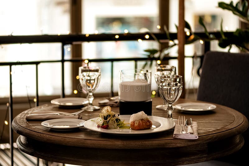 Hemtrevlig atmosfär på restaurangtabellen med ljusa mellanmål, bestick och exponeringsglas royaltyfria bilder Hemtrevlig atmosfär på restaurangtabellen med ljusa mellanmål, bestick och exponeringsglas royaltyfria bilder