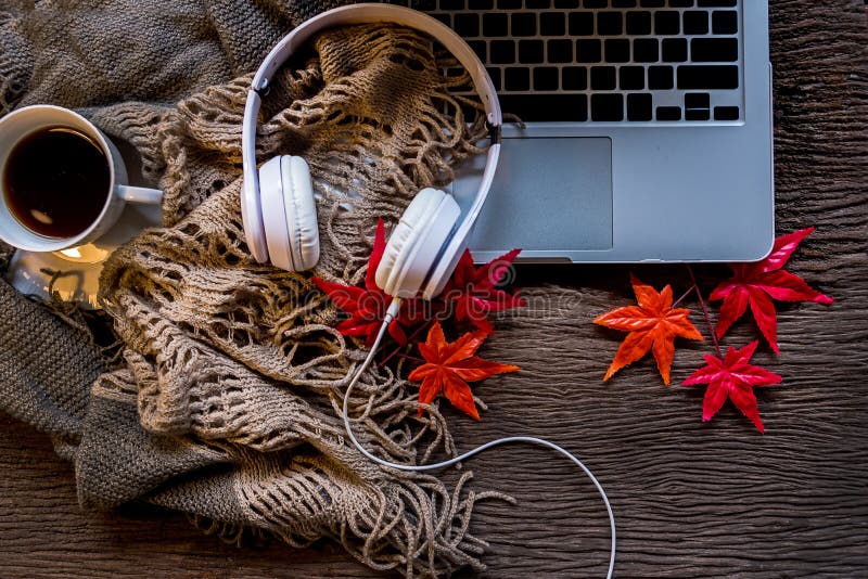Hemtrevlig vinterbakgrund, bärbara datorn med koppen av varmt kaffe med marshmallowen och headphonemusik, varm stucken tröja, kop fotografering för bildbyråer