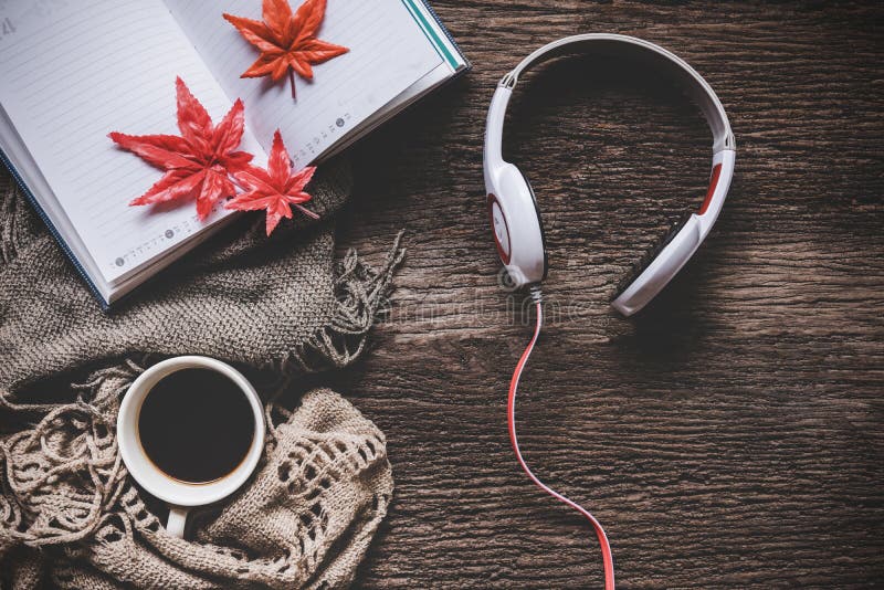 Hemtrevlig vinterbakgrund, kopp av varmt kaffe med marshmallow- och headphonemusik och bokanmärkningen arkivfoton