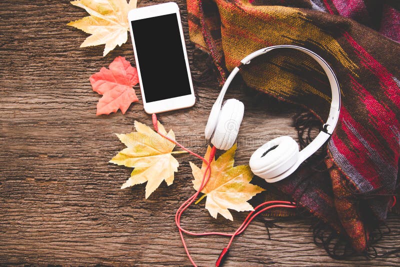 Hemtrevlig vinterbakgrund, kopp av varmt kaffe med marshmallowen och headphonemusik, smart telefon, varm stucken tröja, tappnings arkivfoto