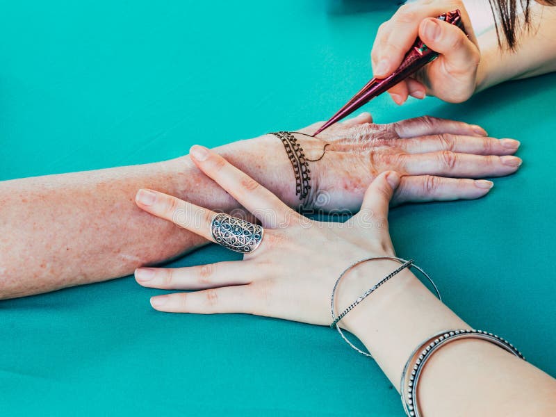 Henna obrazu żeńska ręka Henna obrazu artysta rysuje wzory na ręce Arabskie i Indiańskie henna obrazu tradycje obraz stock Henna obrazu żeńska ręka Henna obrazu artysta rysuje wzory na ręce Arabskie i Indiańskie henna obrazu tradycje obraz stock